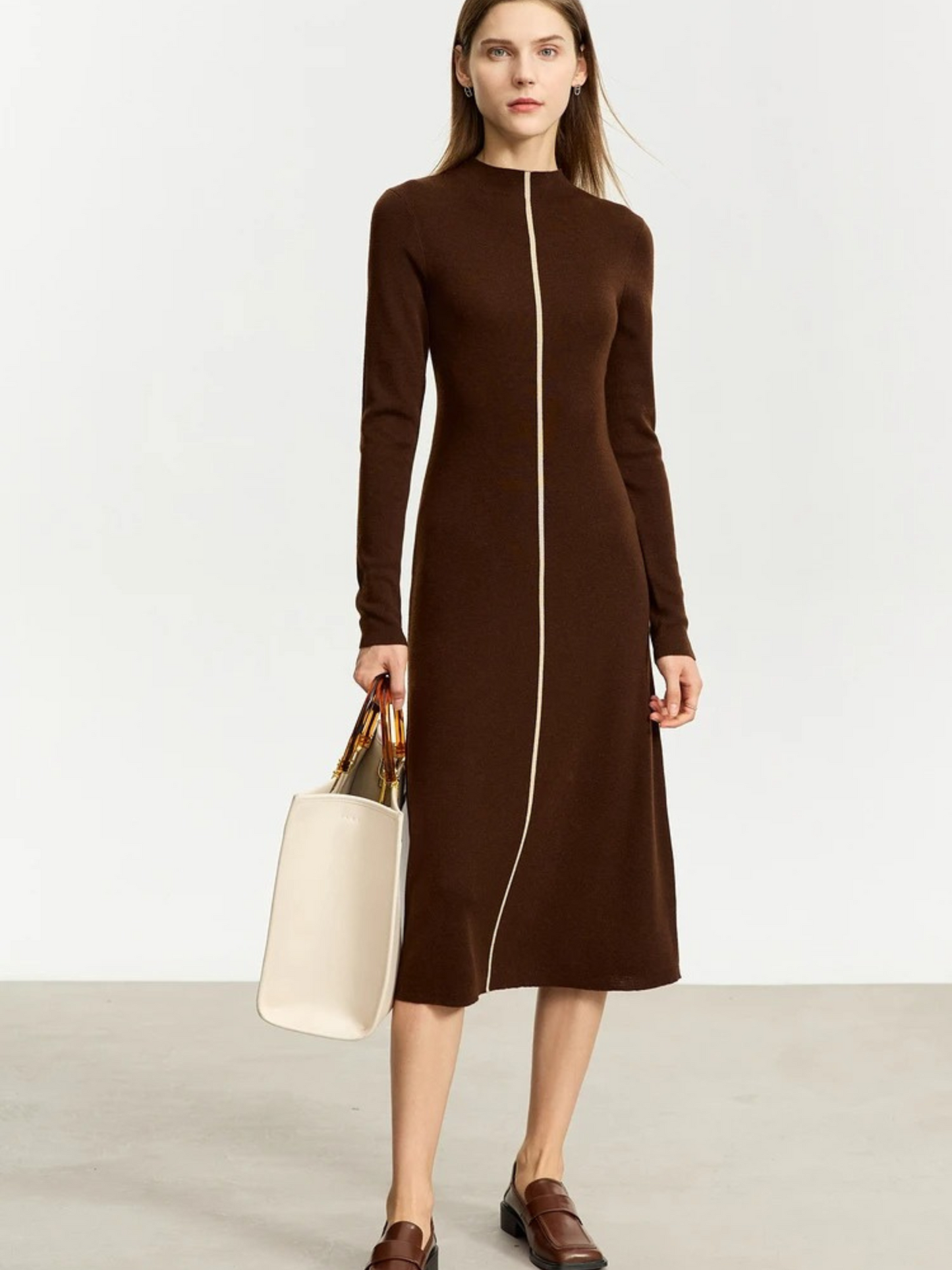 Model wearing chocolate brown long-sleeve dress with center white zipper and mid-length hem