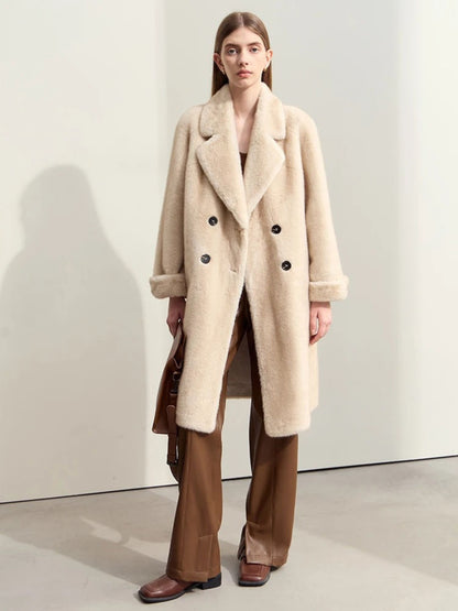 Full-body shot of the model walking slightly forward, showcasing the front and slight movement of the coat. The sleeves are cuffed, and the lapels are large and softly structured