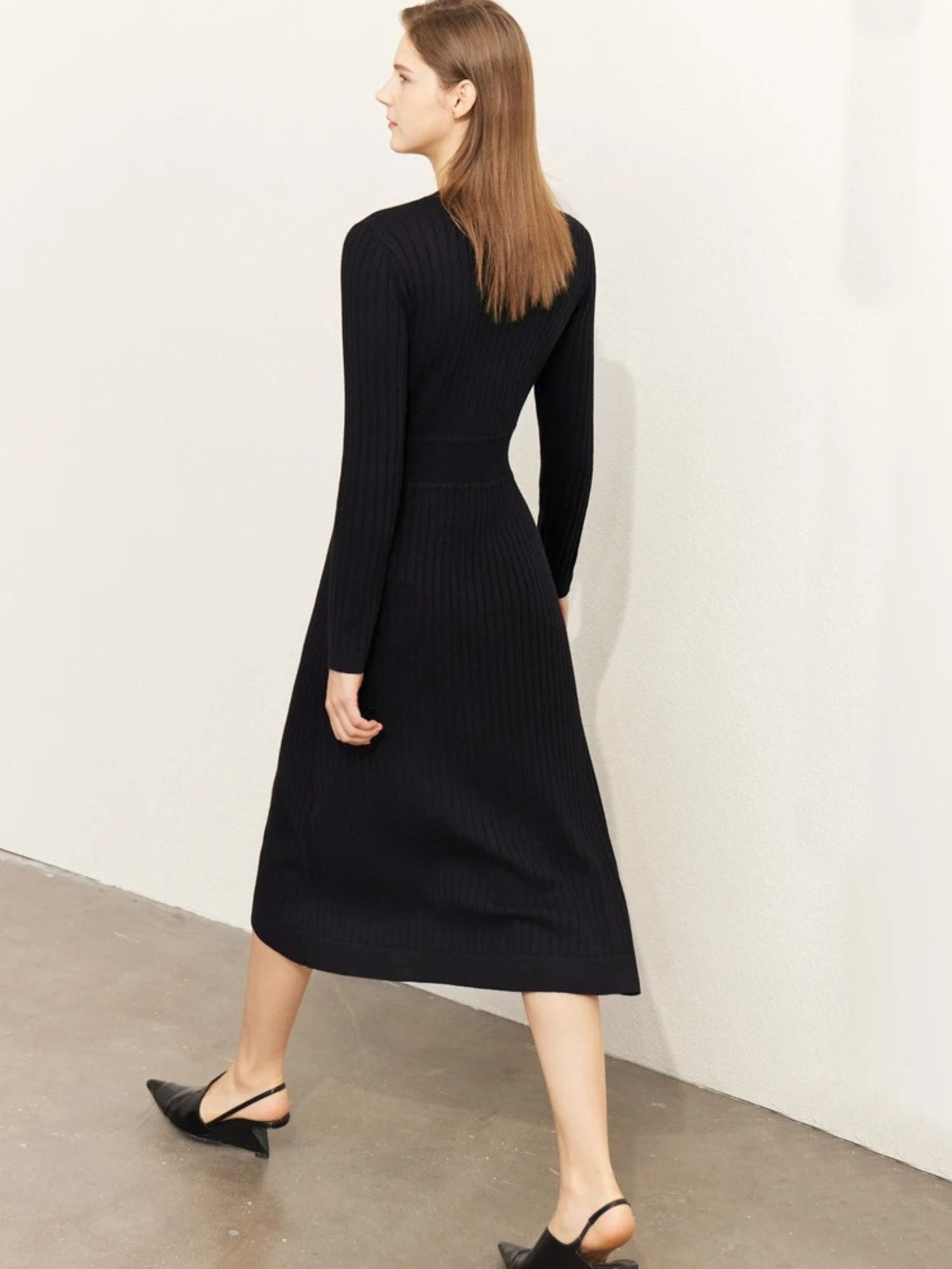 Back view of black ribbed knit midi dress with long sleeves and fitted shape
