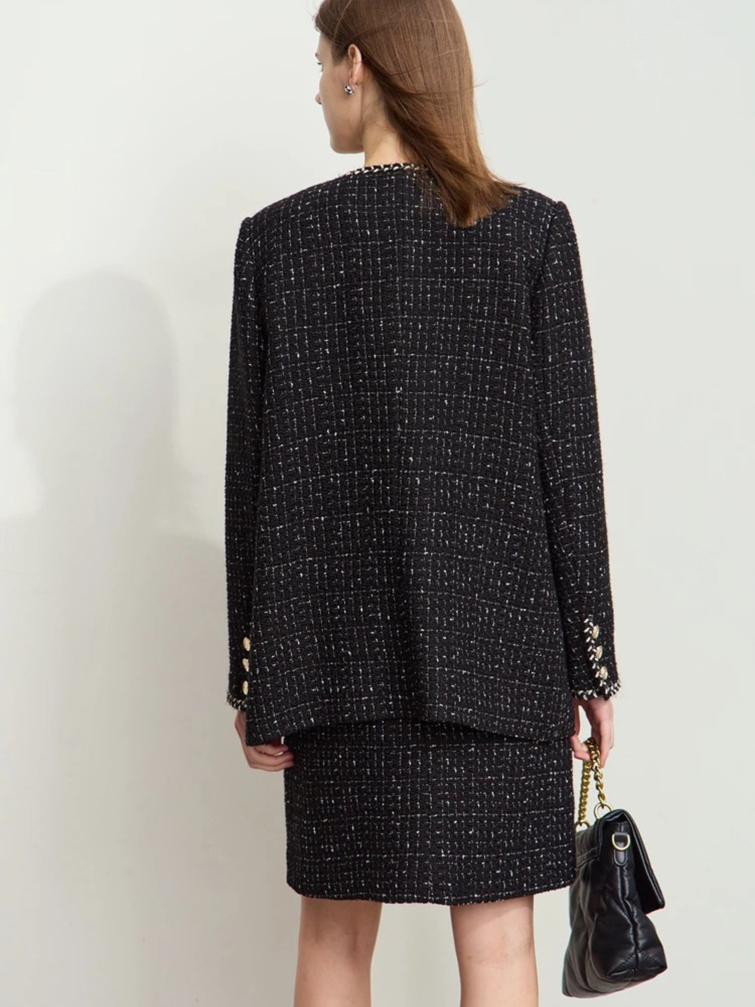 Rear view of the model in the same outfit, showing the full back of the jacket and skirt. The jacket has a boxy, slightly oversized silhouette