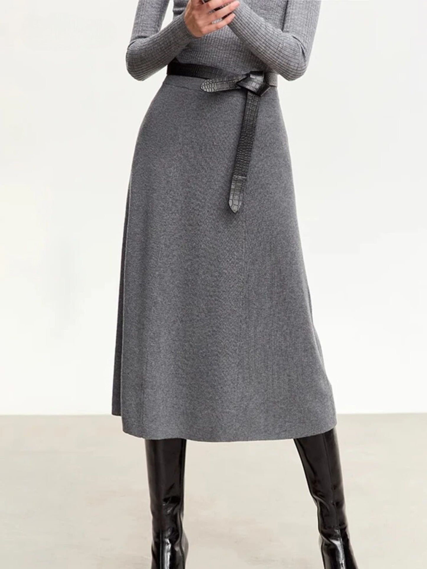 Gray dress with a belt worn by a person on a white background