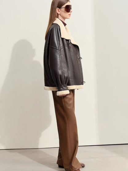 Side view of the model standing in a relaxed pose, looking to the right. The sleeve volume and jacket’s slightly boxy cut are evident