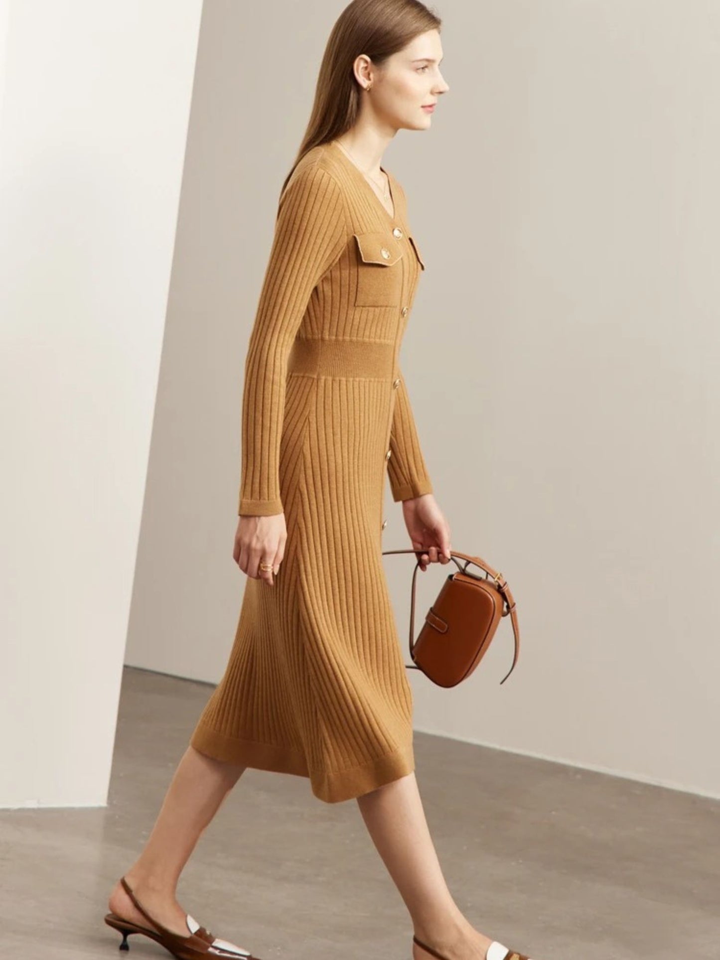 Model walking in camel ribbed knit midi dress with long sleeves, button-front closure, and chest pockets