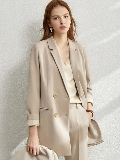 Woman in a beige oversized blazer and matching trousers, paired with a pale blouse and a taupe crossbody bag