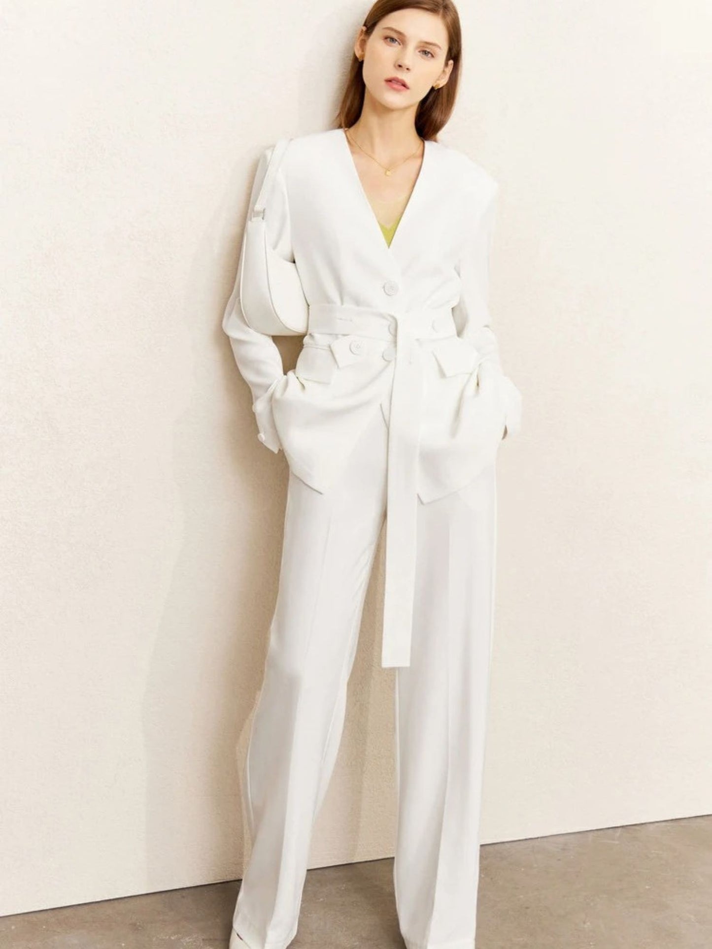 Woman wearing a white outfit against a plain background