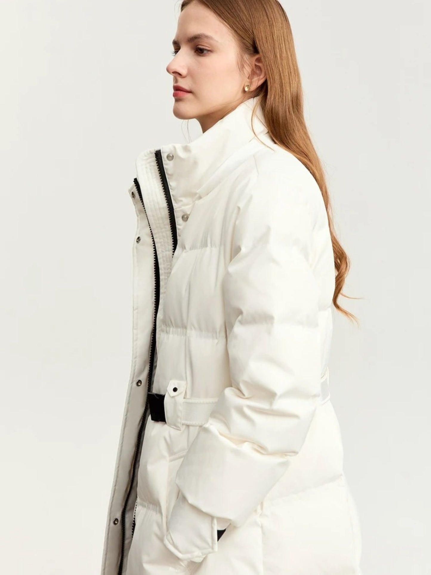 Close-up side view of the white coat's upper portion, showing the high collar and zipper closure