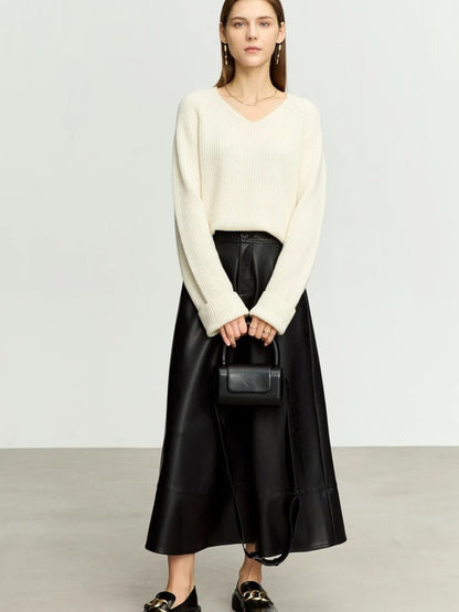 Black flared faux leather midi skirt styled with cream knit sweater and pointed heels