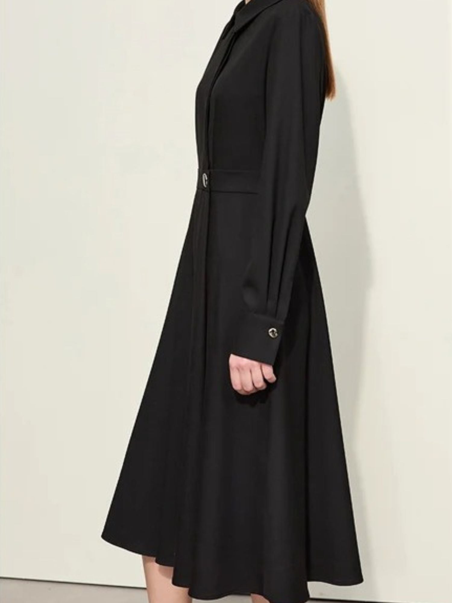 Angled back view of black shirt dress showing clean seam lines and soft drape