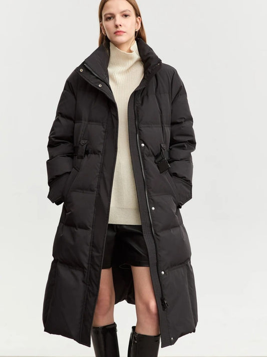 Model in long black puffer coat with oversized fit, worn over cream turtleneck