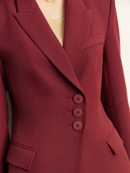 Close-up of burgundy blazer buttons and lapel, showing deep red fabric texture