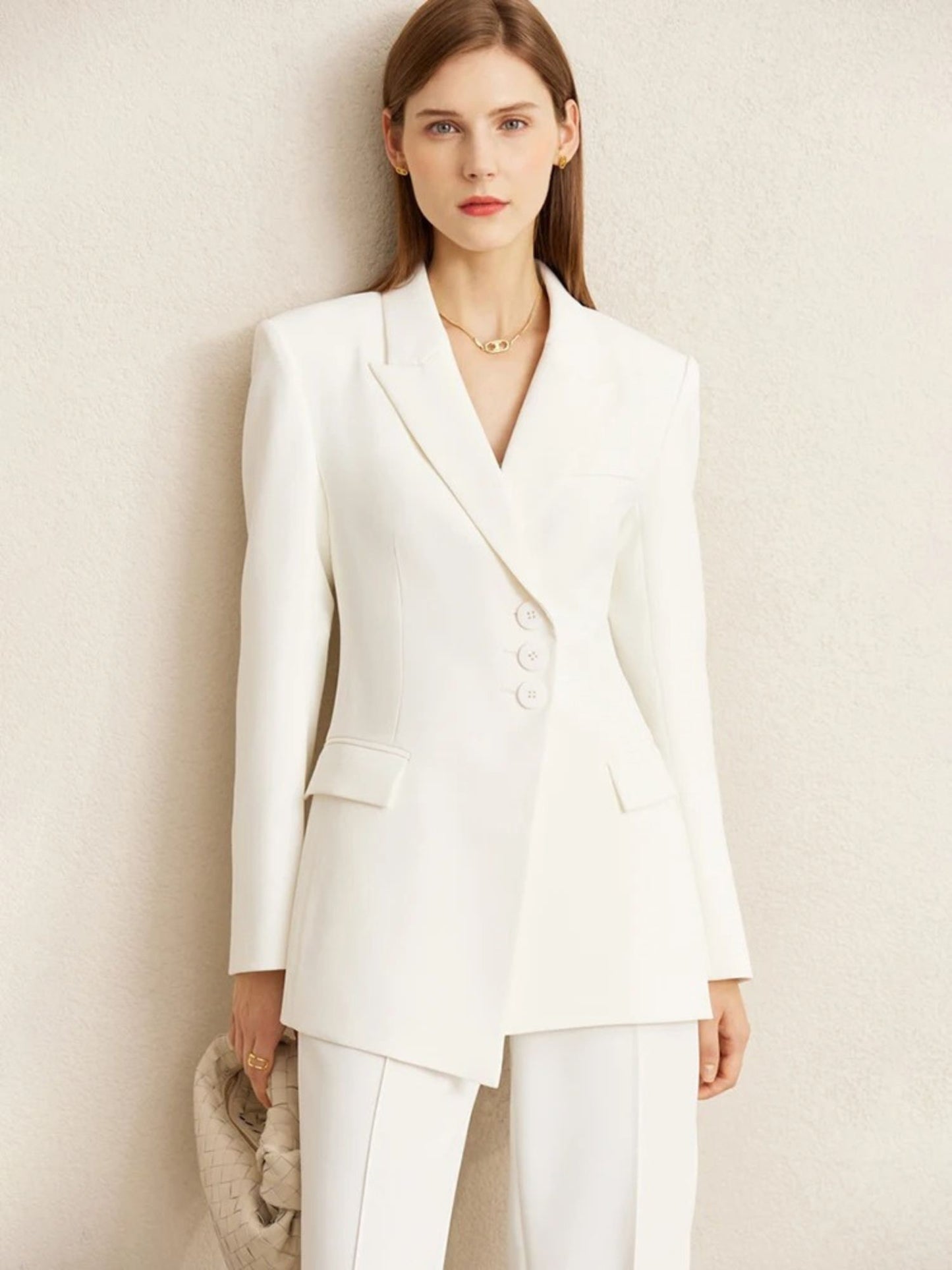 Woman in white pantsuit featuring longline blazer and straight-leg trousers
